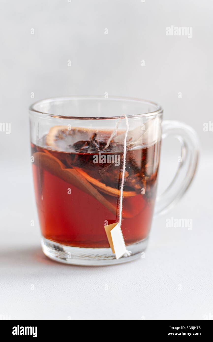 Close-up of a glass cup with a mulled tea teabag and assorted spices Stock Photo