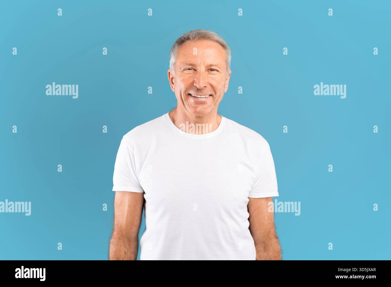 Happy Mature Man Smiling in Studio With Blue Background Stock Photo