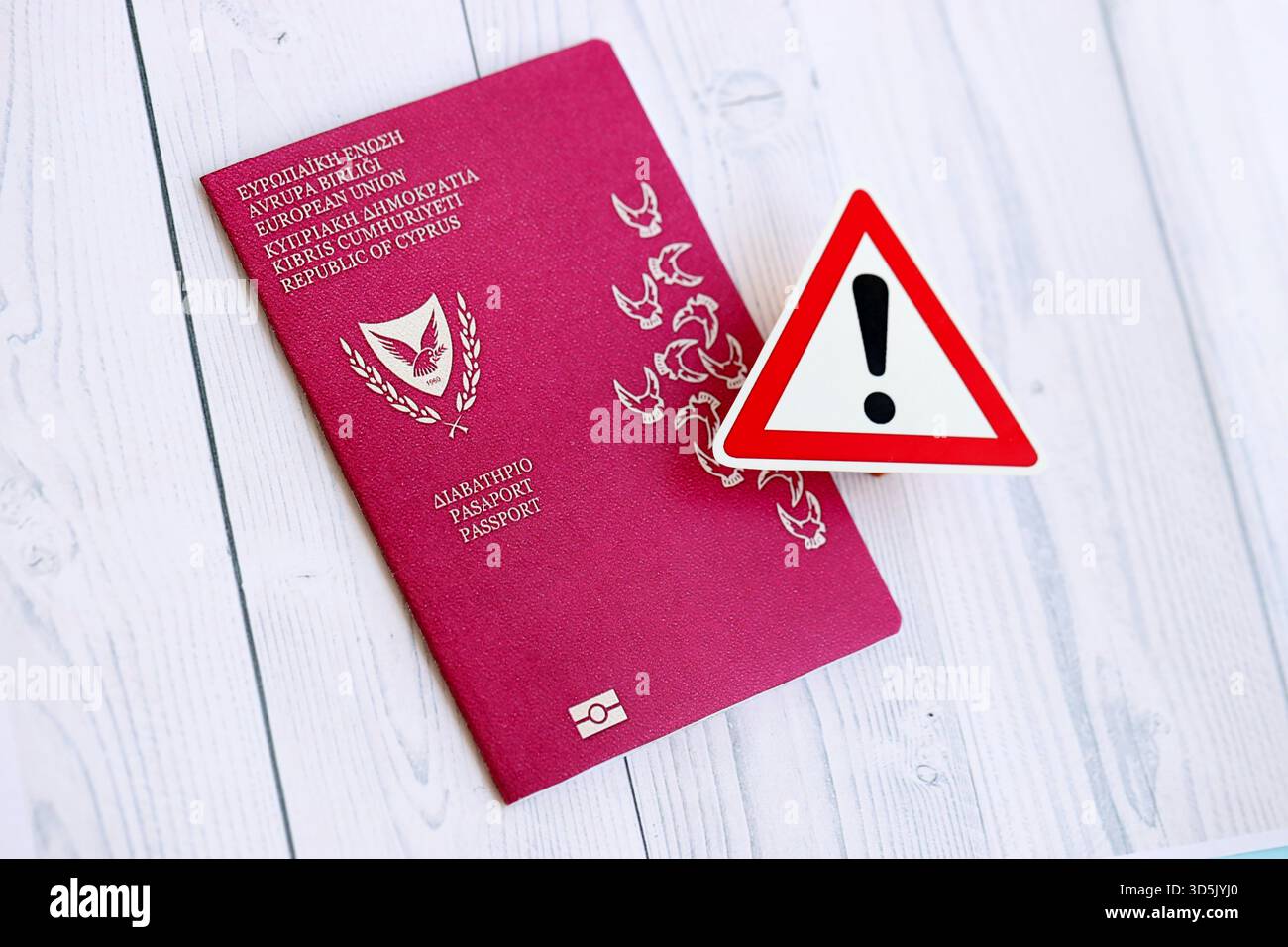 Kyprus passport with exclamation sign on white wooden background close up. Problems with citizenship in Europe concept Stock Photo