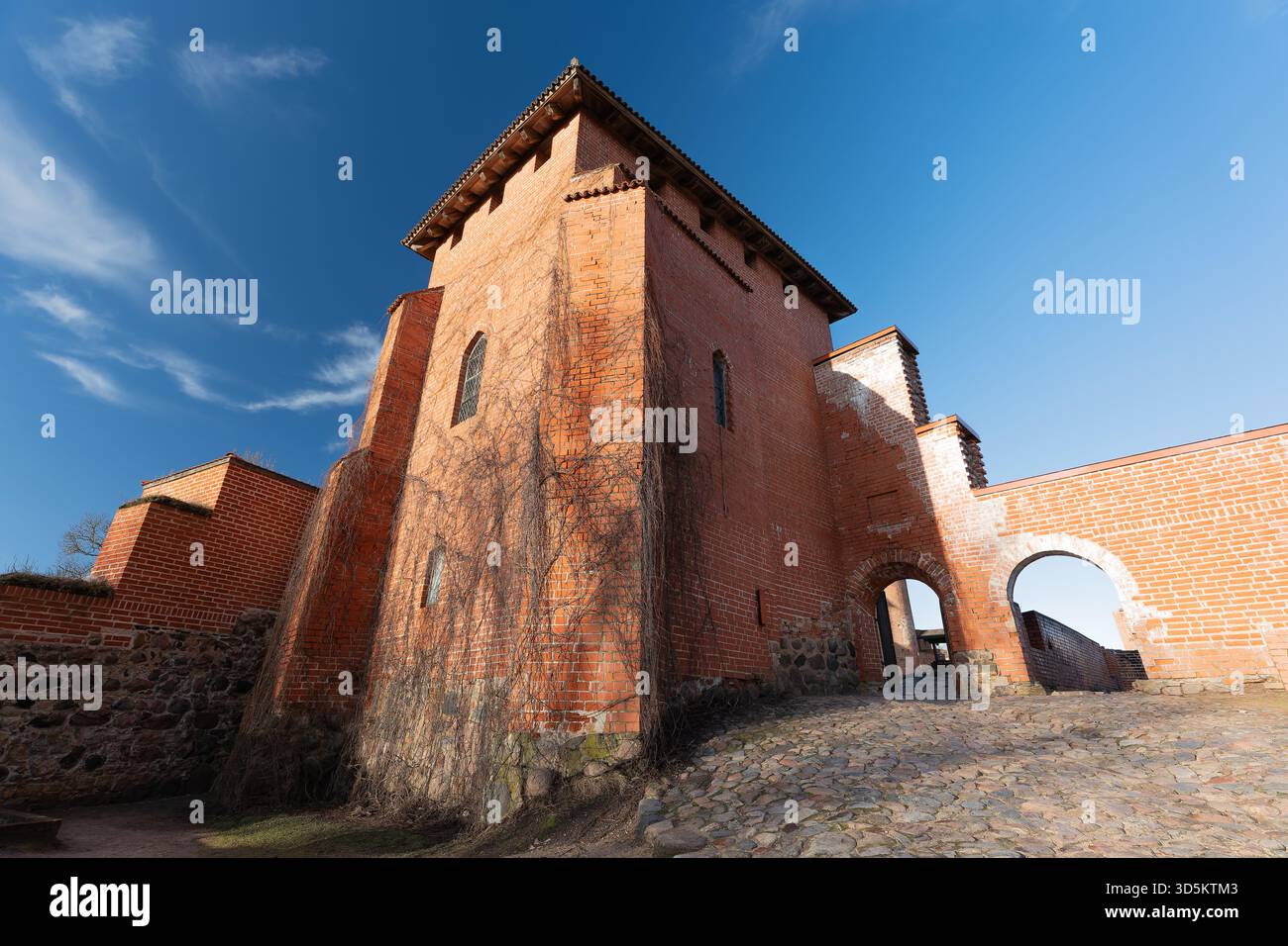 Historic castle walls against a blue sky background, over time it has been used as a fortress, photographed with a wide-angle lens from different angl Stock Photo