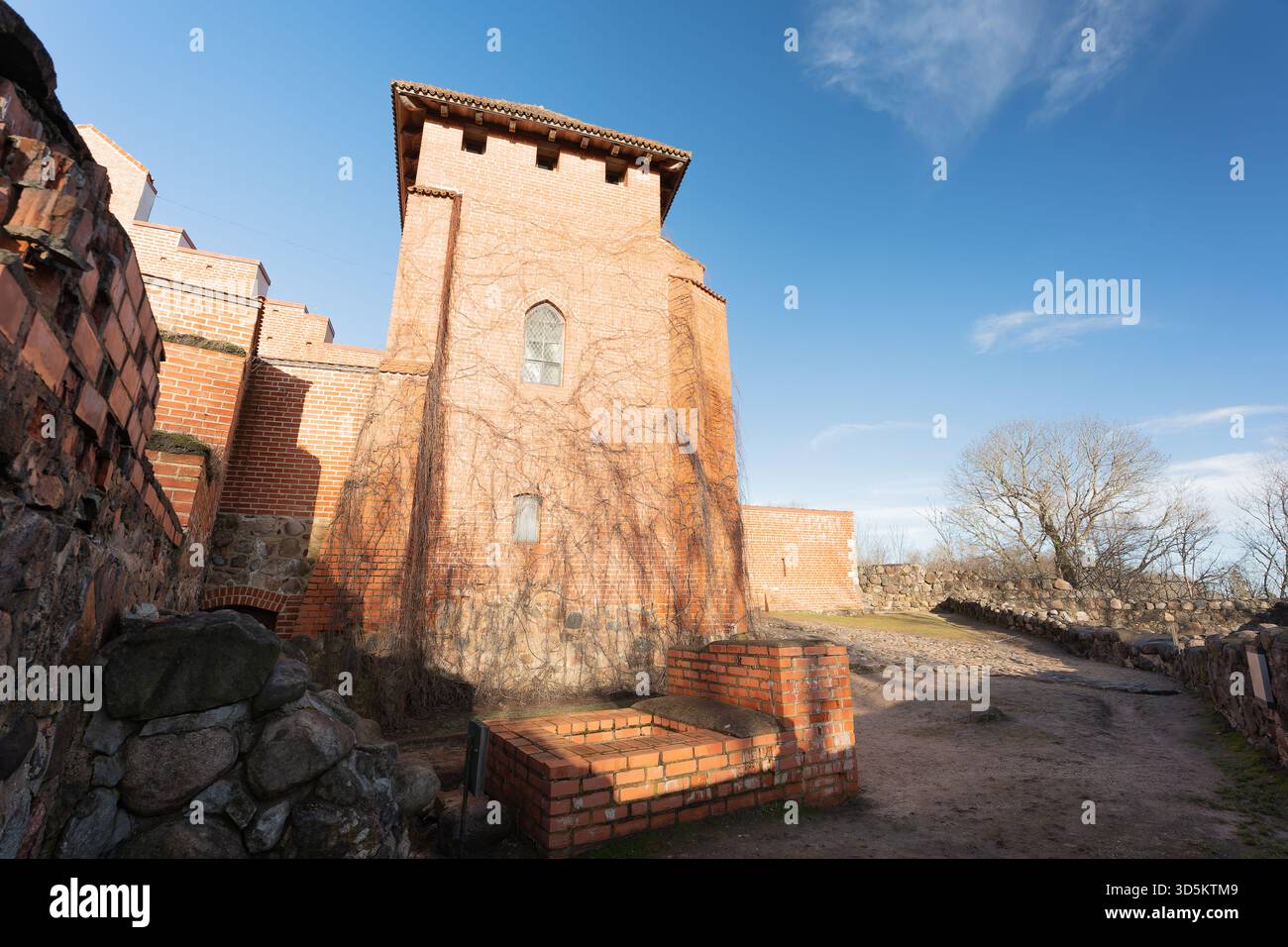Historic castle walls against a blue sky background, over time it has been used as a fortress, photographed with a wide-angle lens from different angl Stock Photo