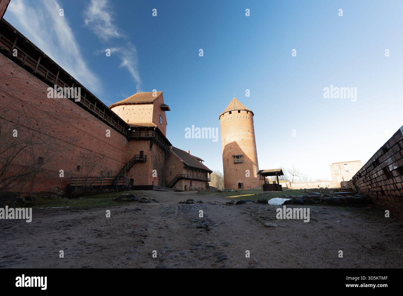 Historic castle walls against a blue sky background, over time it has been used as a fortress, photographed with a wide-angle lens from different angl Stock Photo
