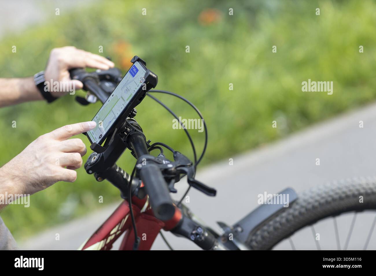 Man planning route using GPS navigation application in mobile phone on his bicycle bike Stock Photo