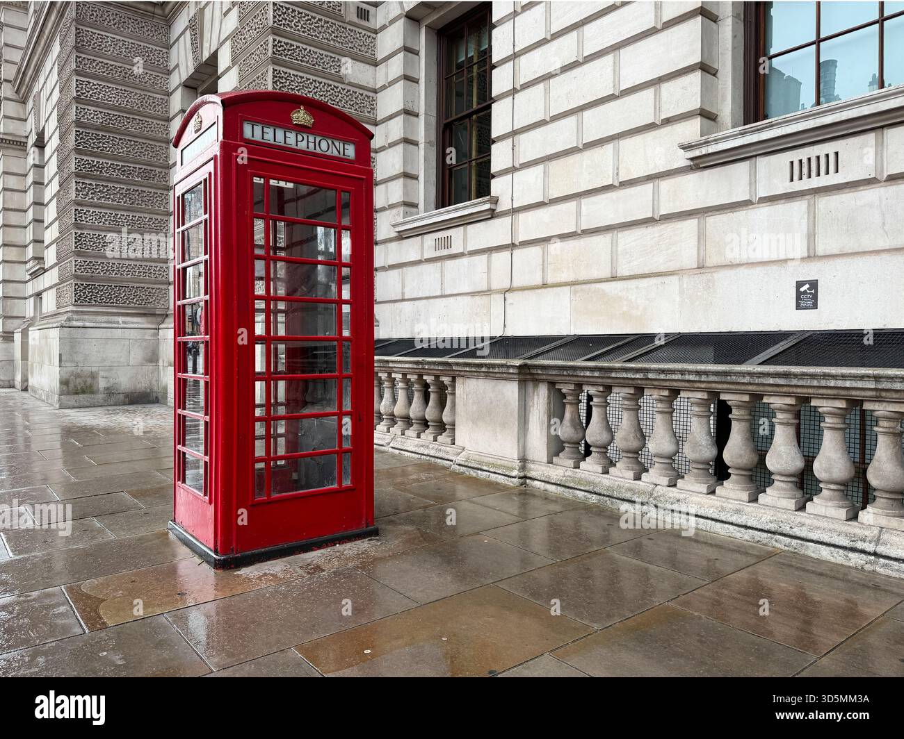 London, UK - September 10, 2025; Classic K6 design British telephone box in wet weather on street Stock Photo