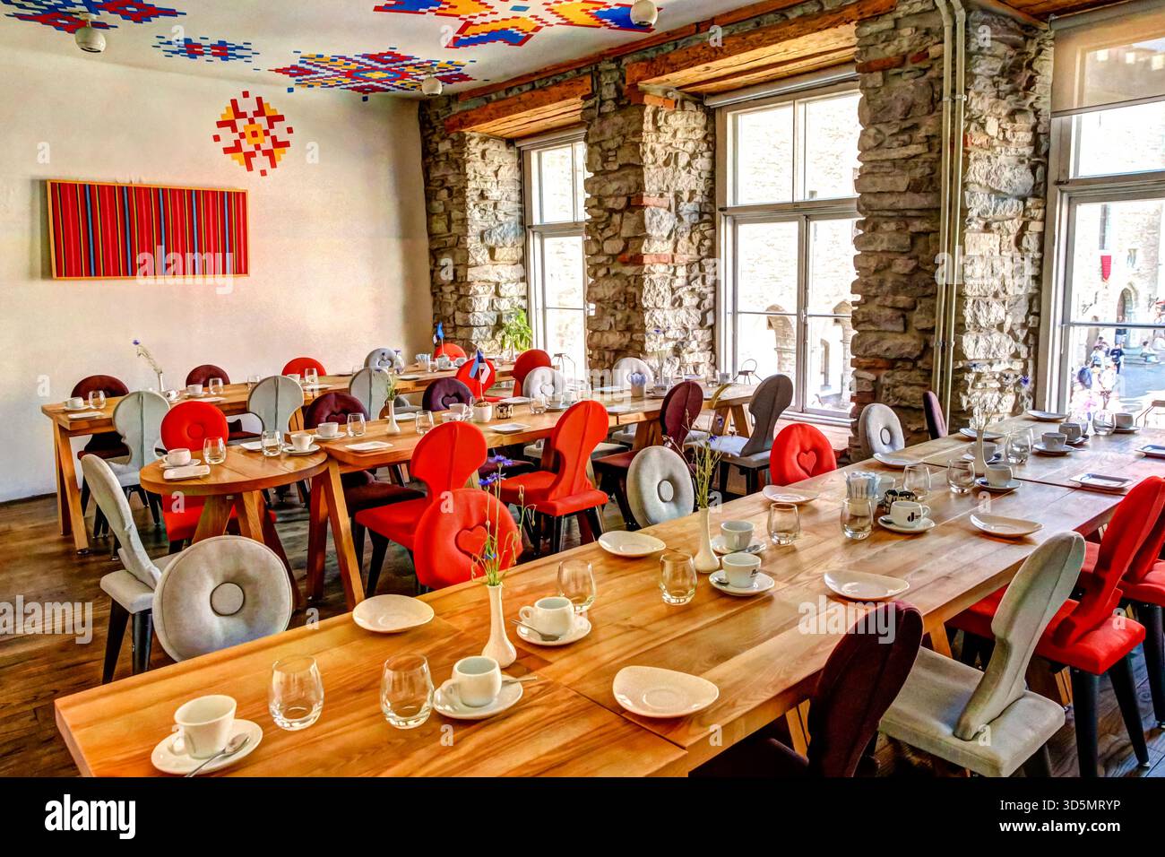 Colorful restaurant interior in Tallinn with set tables, vibrant chairs ...