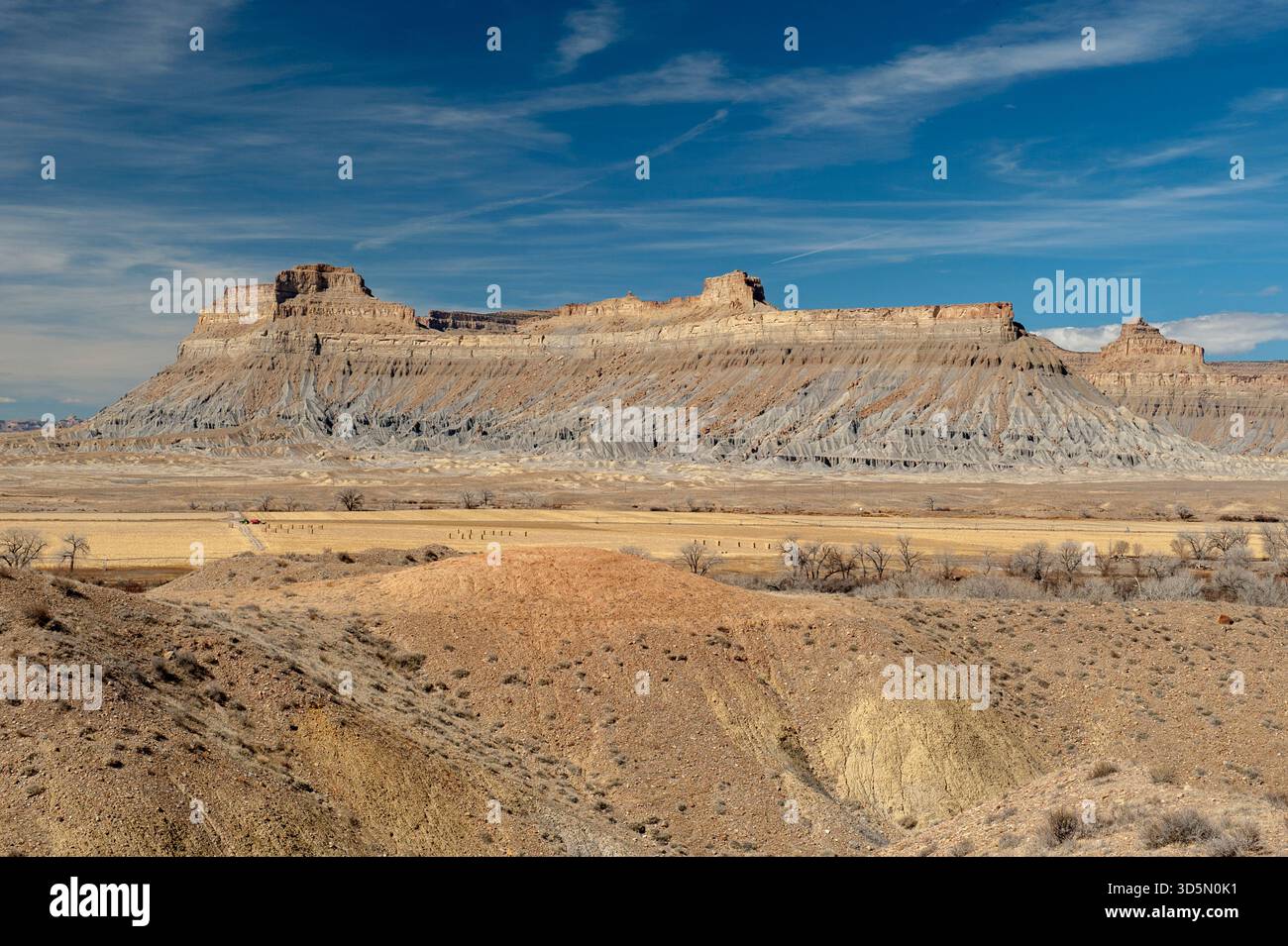 Battleship Butte, a massive feature made of Mancos shale (bottom) and Mesaverde Group formations (top) in the desert near Green River, Utah. Stock Photo