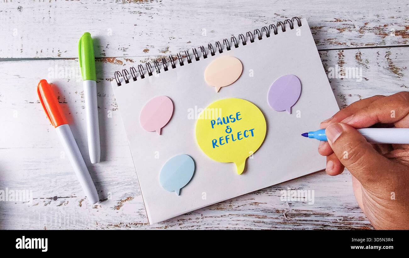 Pause and Reflect Mindfulness Concept with Hand Writing on Speech Bubble Notes and Marker Pens Stock Photo