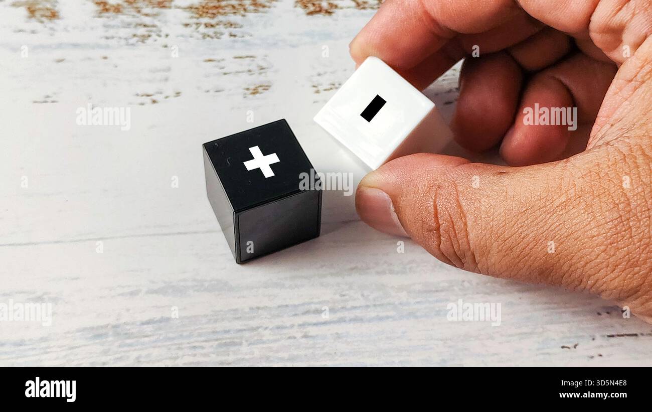 Hand Holding Black and White Cubes with Plus and Minus Symbols ...