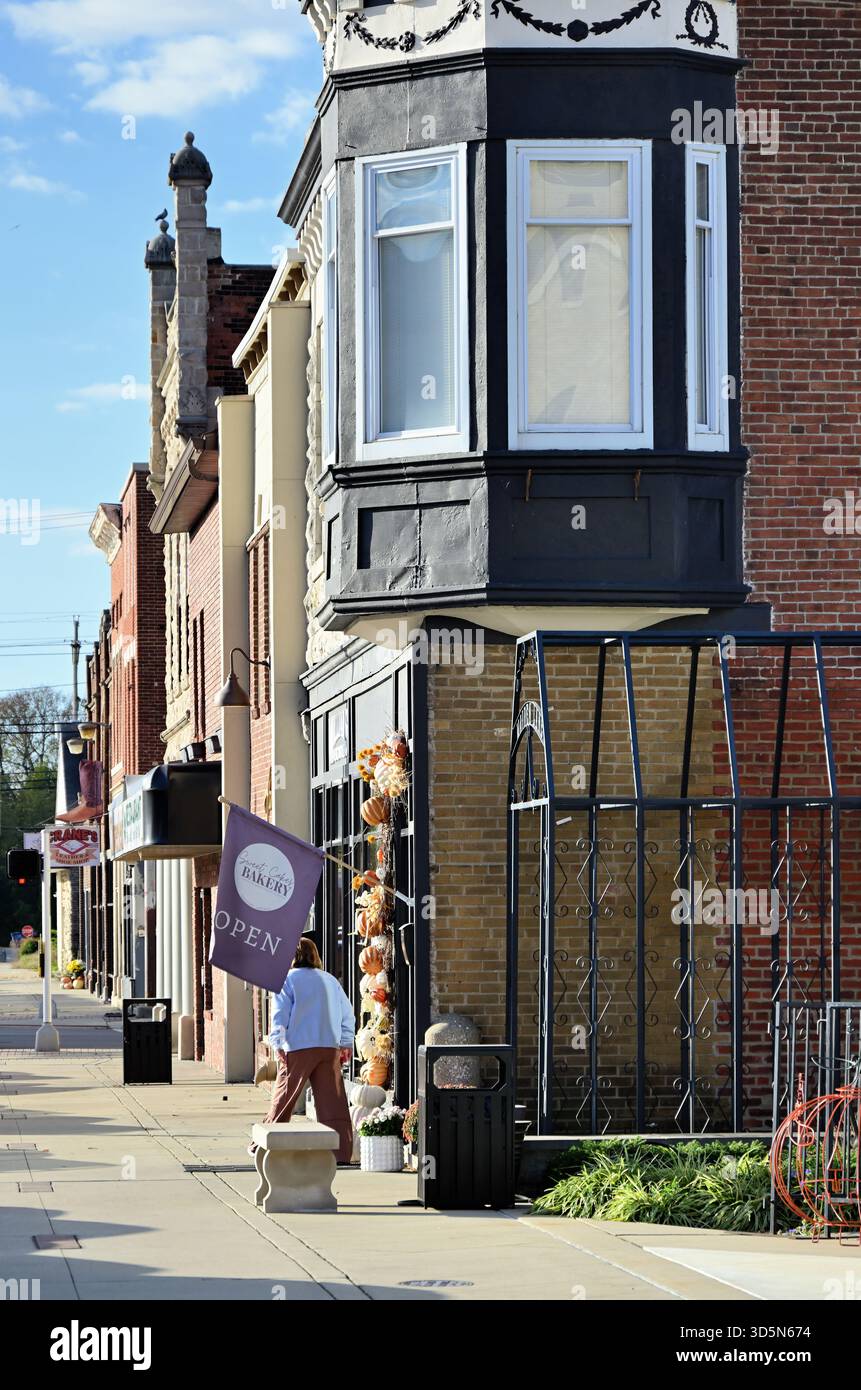Bedford, Indiana, USA. A lone person emerges onto a sunlite street in a small town in south central Indiana. Stock Photo