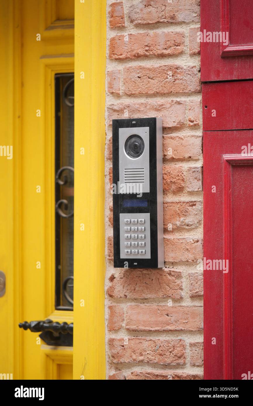 Modern intercom system mounted on a colorful brick wall Stock Photo