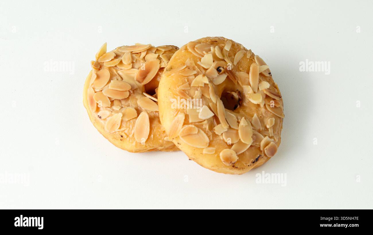 two donuts with almond topping on a white background Stock Photo