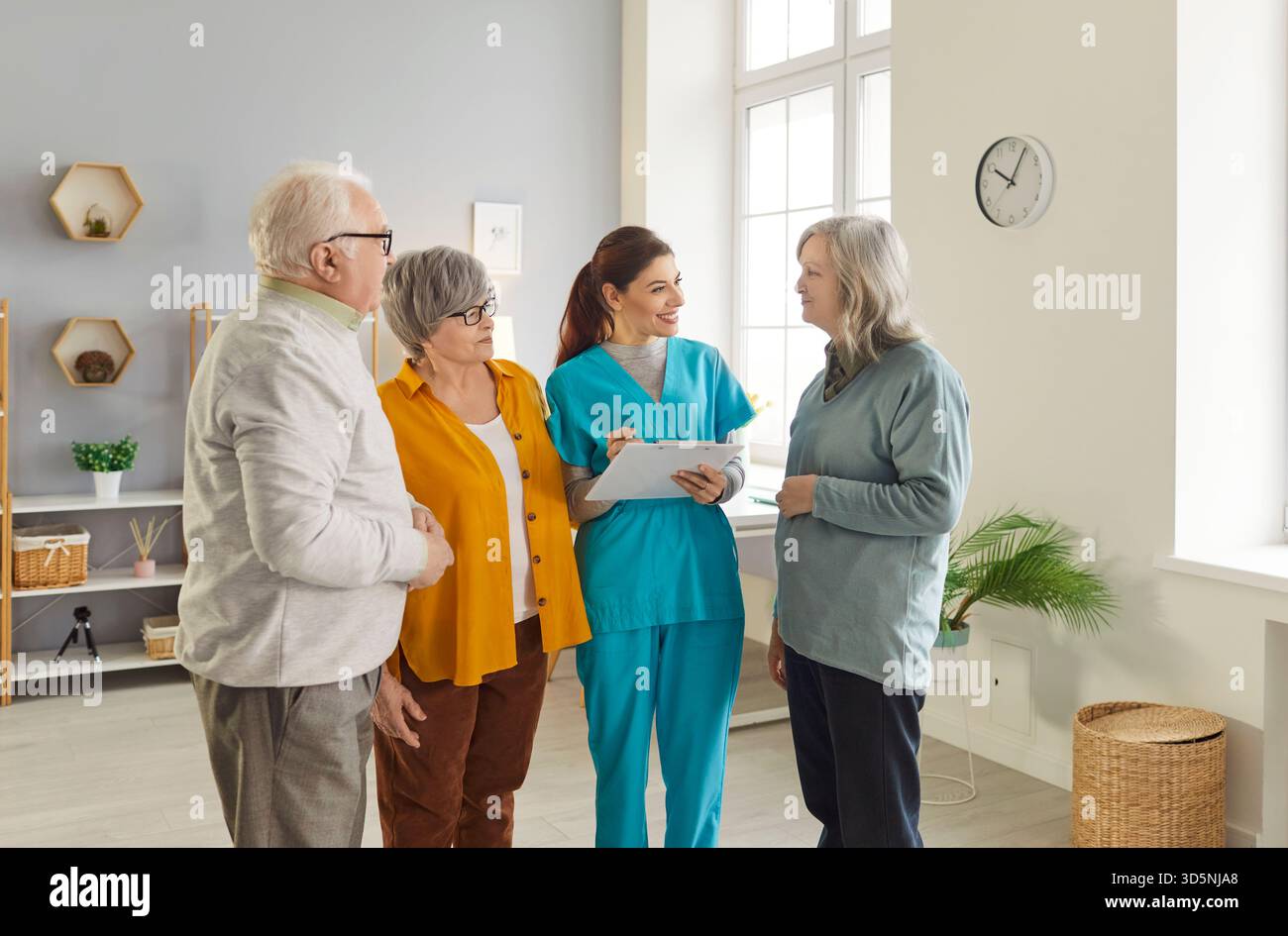 Group of senior people, caring smiling nurse, geriatric medicine caretaker providing help, support Stock Photo