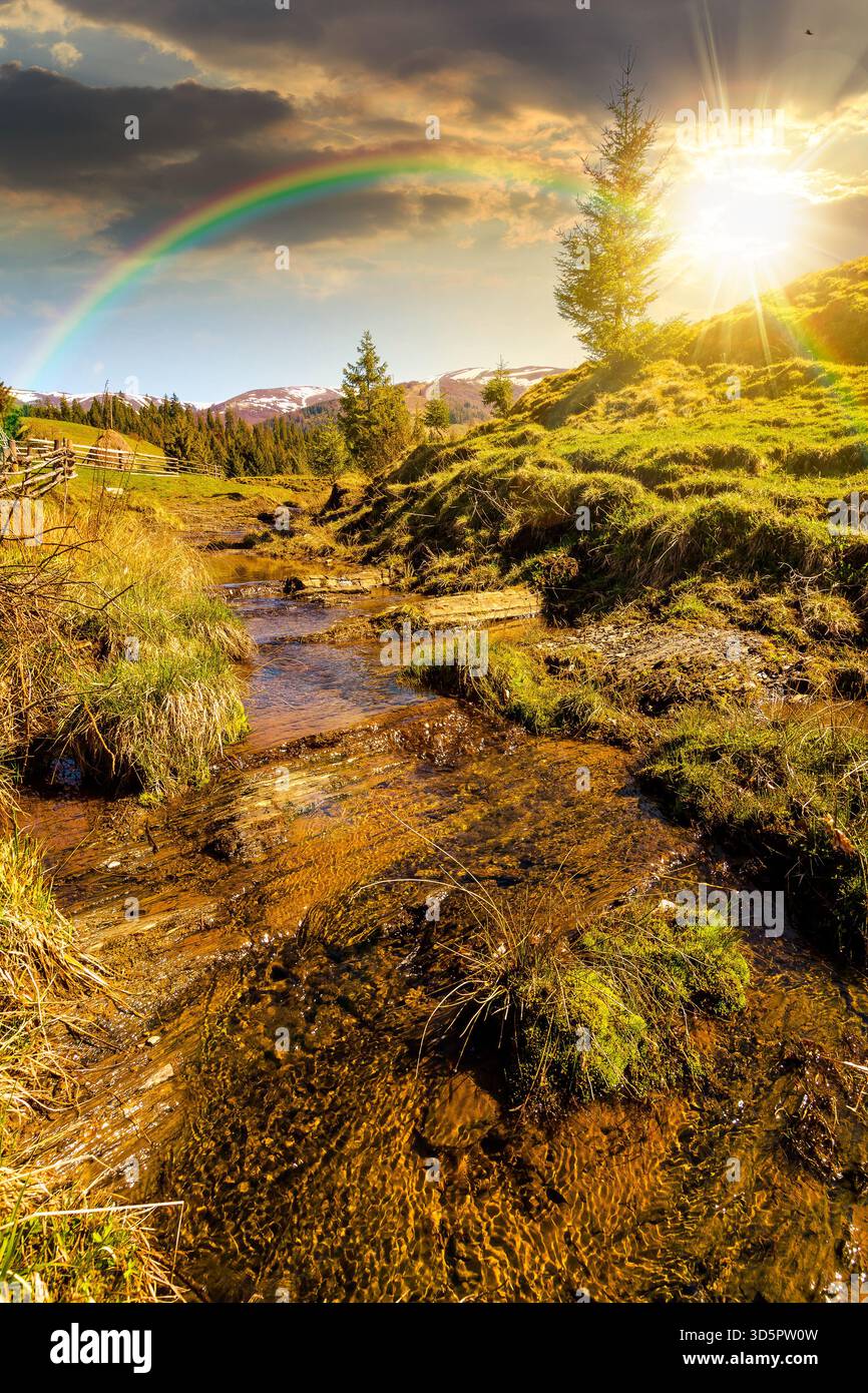 rural scene of mountain landscape in spring at sunset. green countryside with forested hills in evening light. beautiful valley sustainable developmen Stock Photo