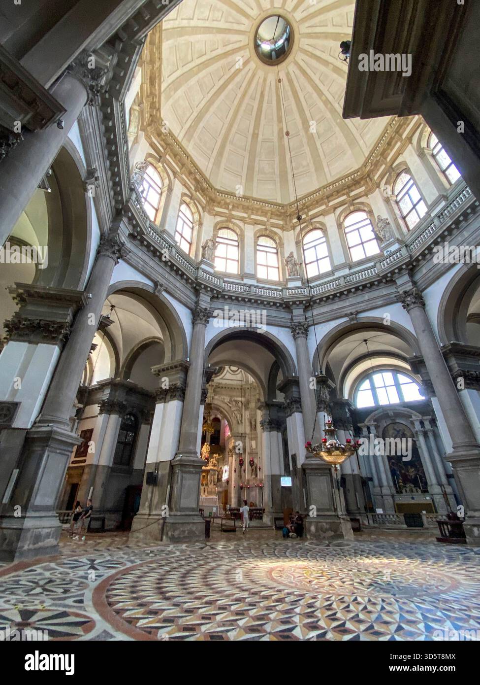 Soft sunlight bathed the mosaic marble titled octagon-shaped floor from the high octagonal-shaped dome of the Basilica di Santa Maria della Salute (Ch - Smartphone Captured Stock Image