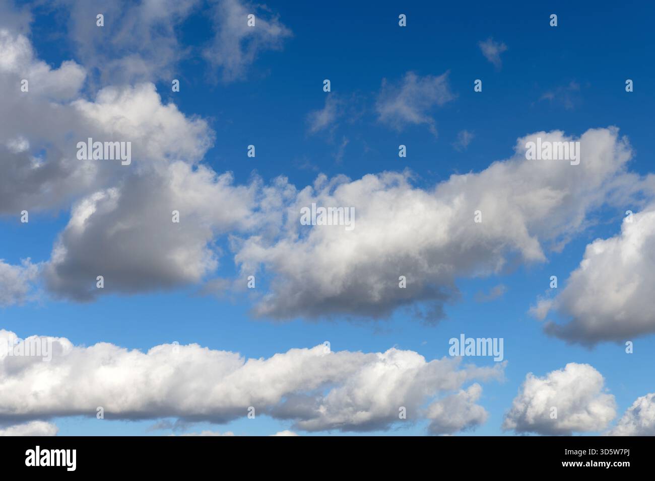 White cumulus clouds drifting across a blue sky Stock Photo