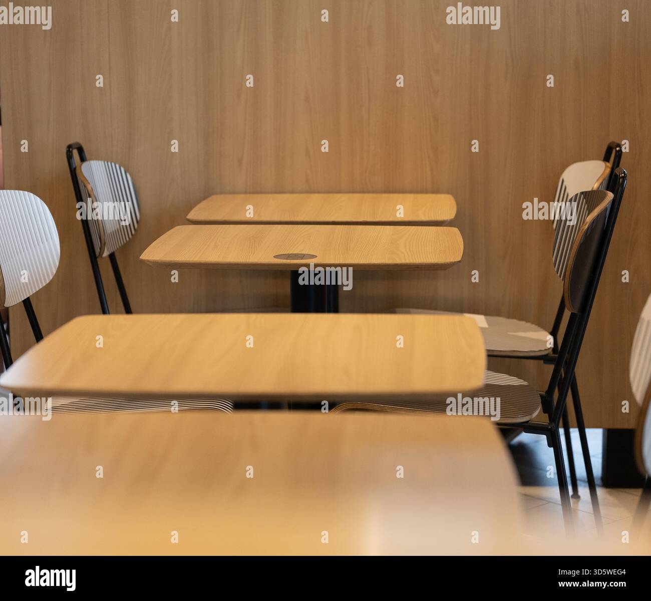 Modern cafe setting with empty wooden tables and chairs in a cozy space ...