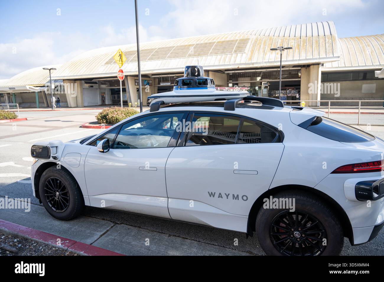Waymo autonomous vehicle with rooftop sensors parked at curb outside ...