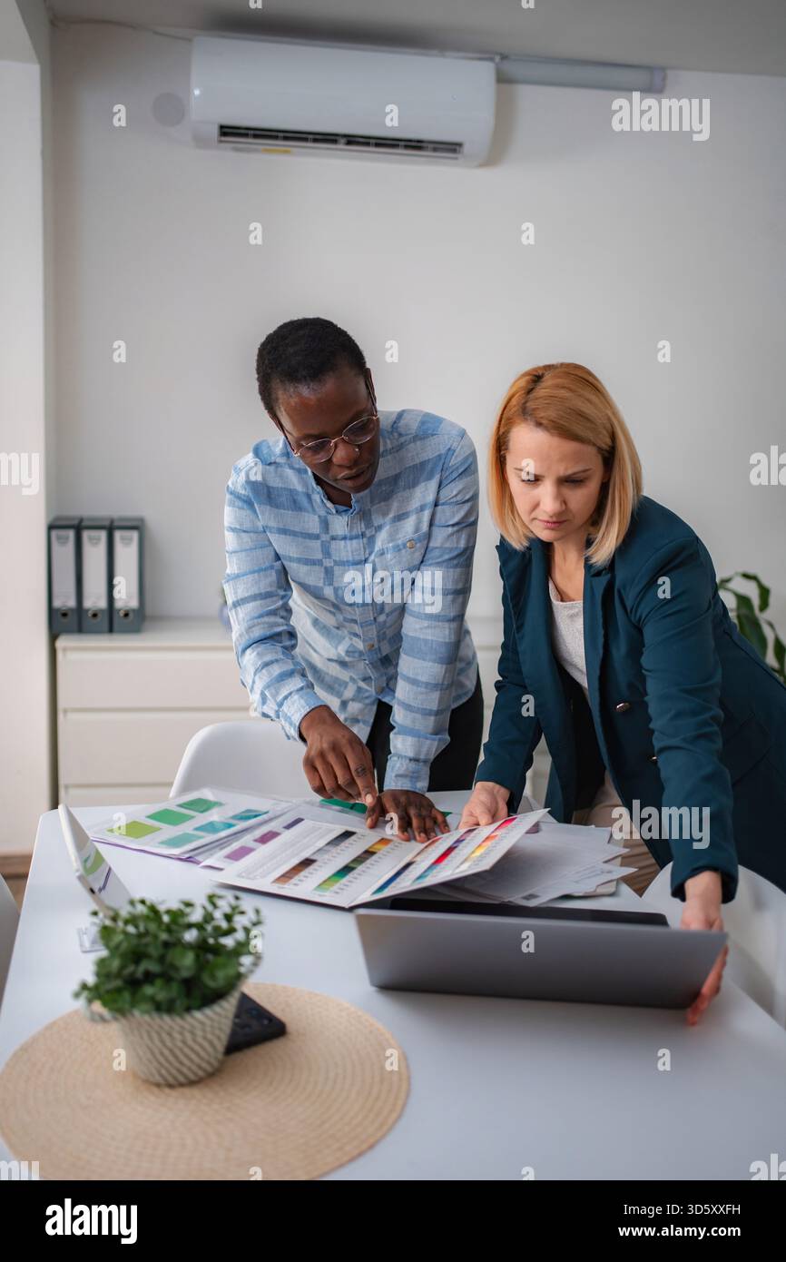 Diverse colleagues collaborating on design project choosing color palette Stock Photo