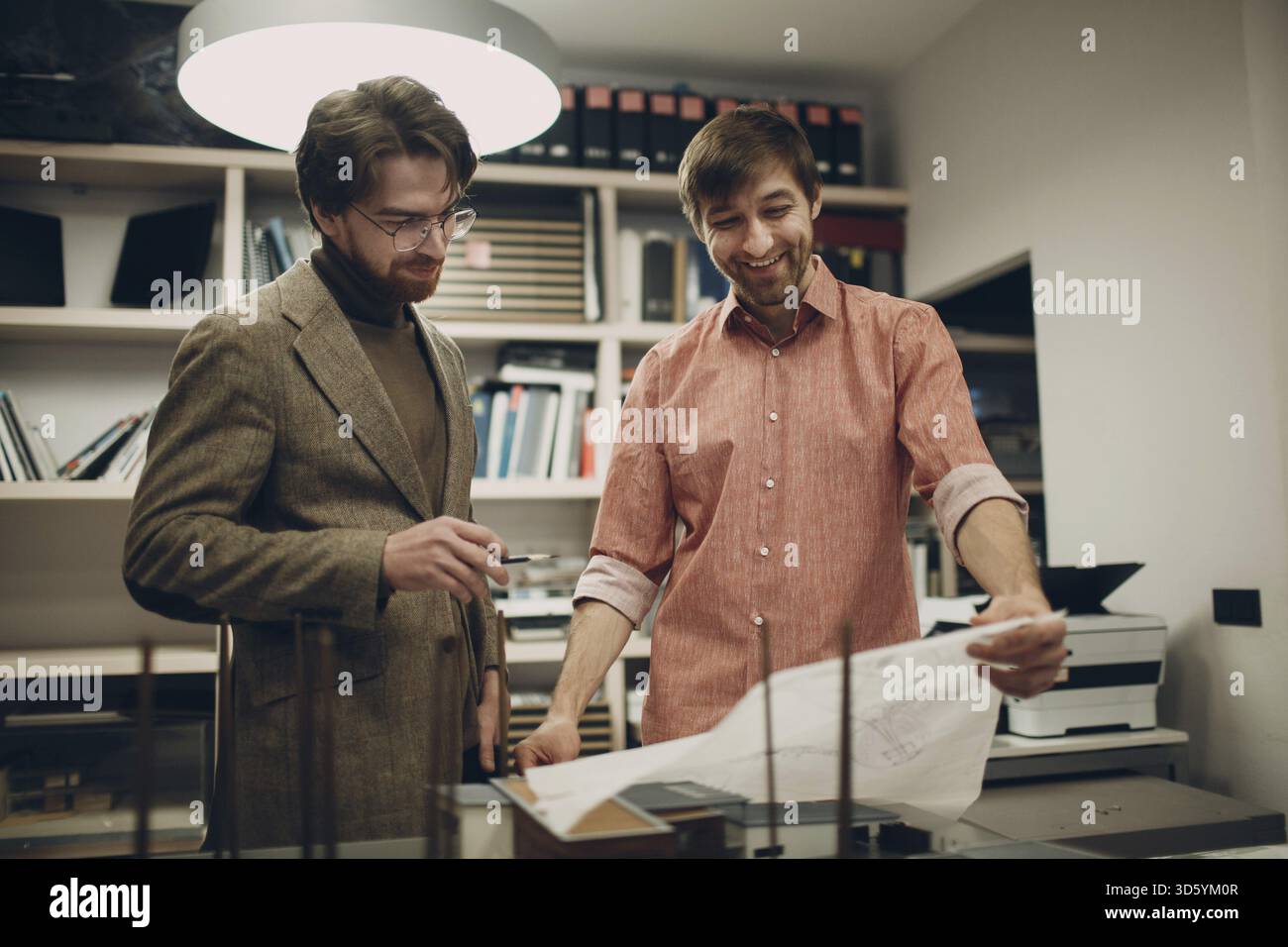 Architect with blueprints and layout design project at office bureau Stock Photo