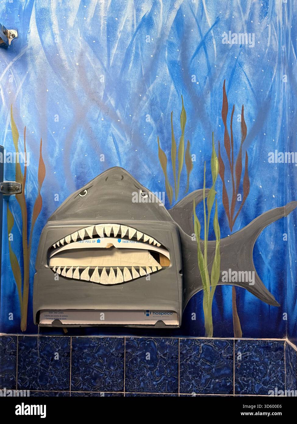 Shark-Themed Toilet Seat Liner Dispenser in Underwater Mural Bathroom - Smartphone Captured Stock Image