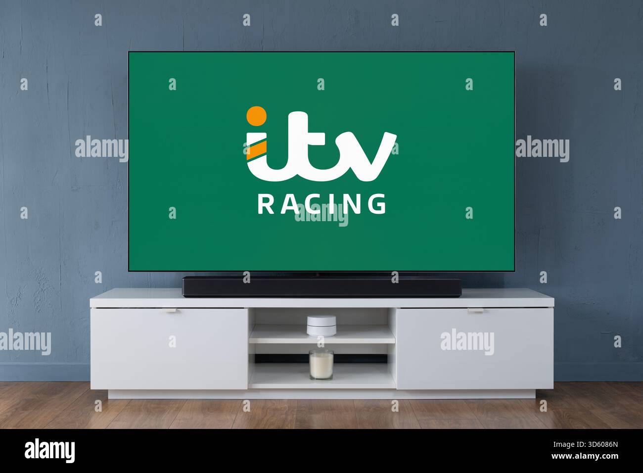 A widescreen OLED television showing the logo of ITV Racing seen in a contemporary living room. Stock Photo
