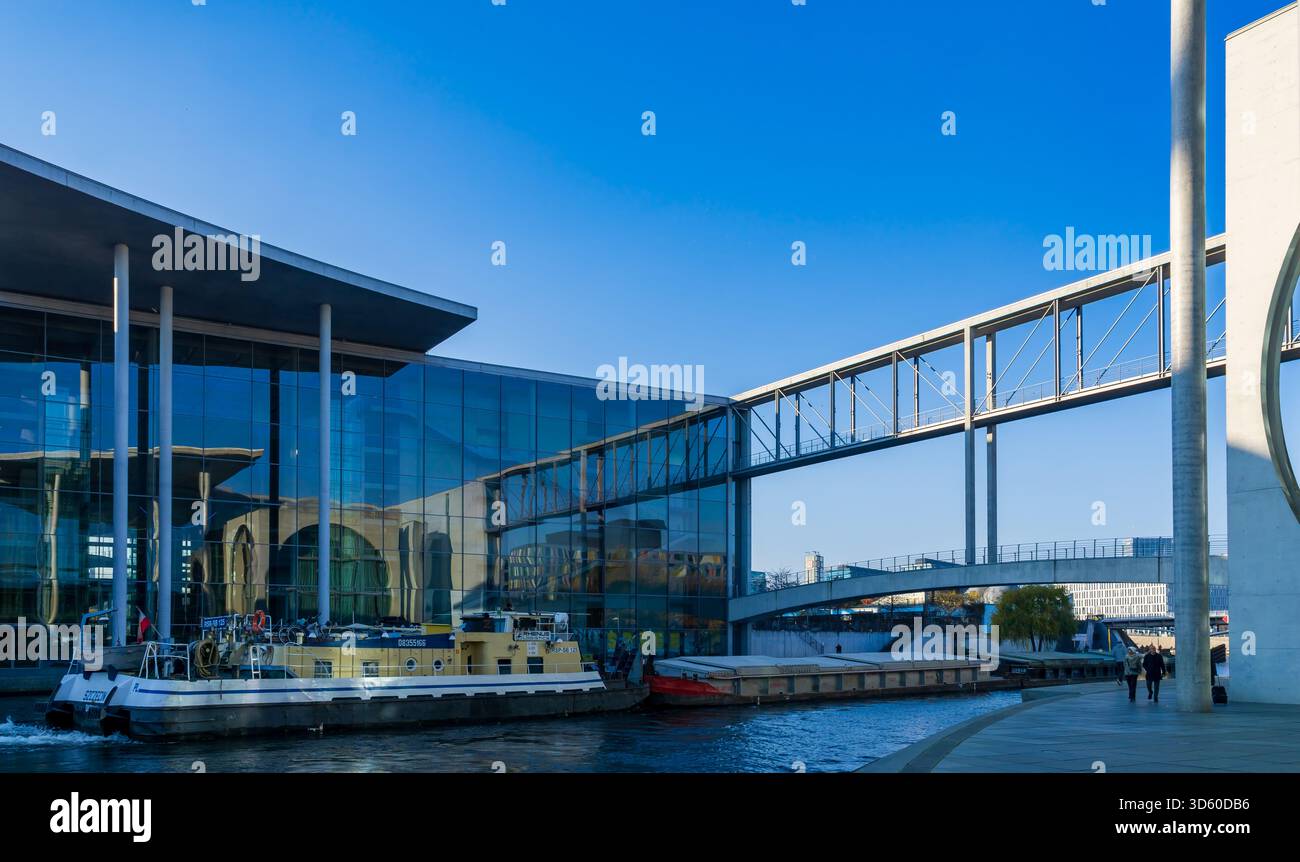 The Marie-Elisabeth-Lüders-Steg pedestrian bridge in Berlin’s government district, captured with a freight barge navigating the Spree River. Stock Photo