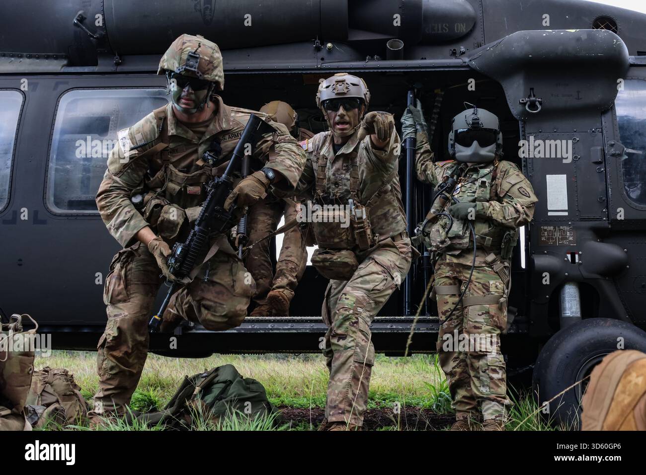 A U.S. Army Jungle Instructor directs students as they exit a UH-60M ...