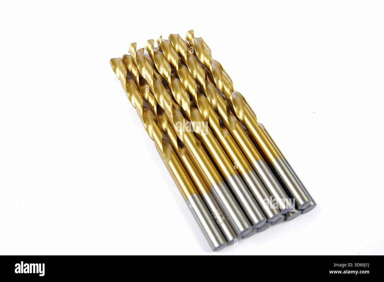 a row of gold metal drill bits on a white background Stock Photo
