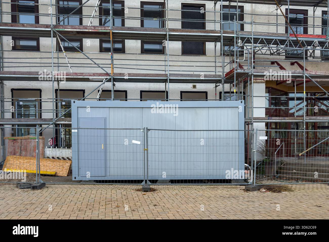 A construction site features a large storage container surrounded by ...