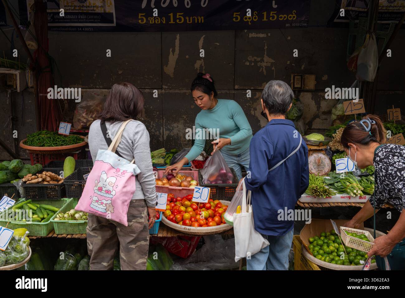 People buy vegetables at a stall in Bang Kapi Fresh Market. (Photo by ...
