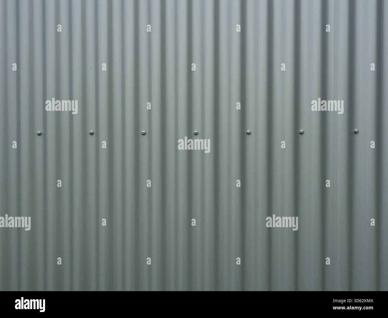 Vertical gray corrugated metal panels with rivets. Matte light and shadow play. Industrial aesthetic. Copyspace. Stock Photo