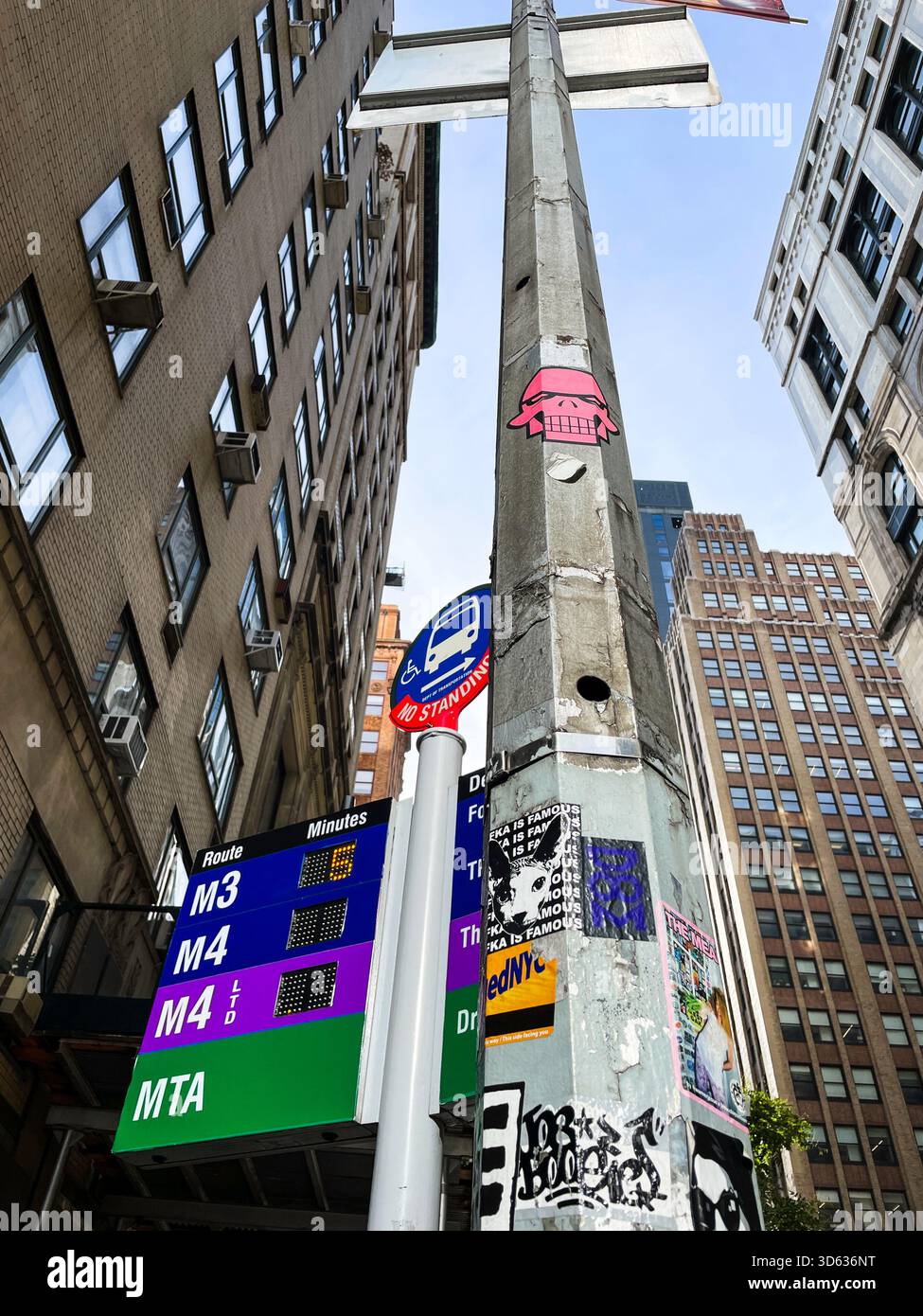Three bus line MTA sign and a light pole covered in graffiti at E. 34th St. and Madison Avenue, 2025, New York City, United States - Smartphone Captured Stock Image