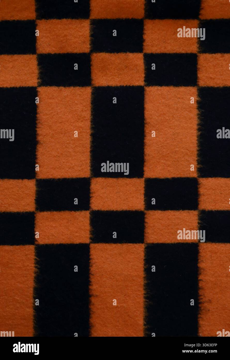 Bright black and orange checkered blanket abstract pattern background, warmth Stock Photo