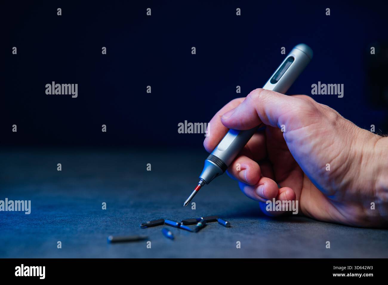 Electric mini screwdriver and several different interchangeable bits. Stock Photo