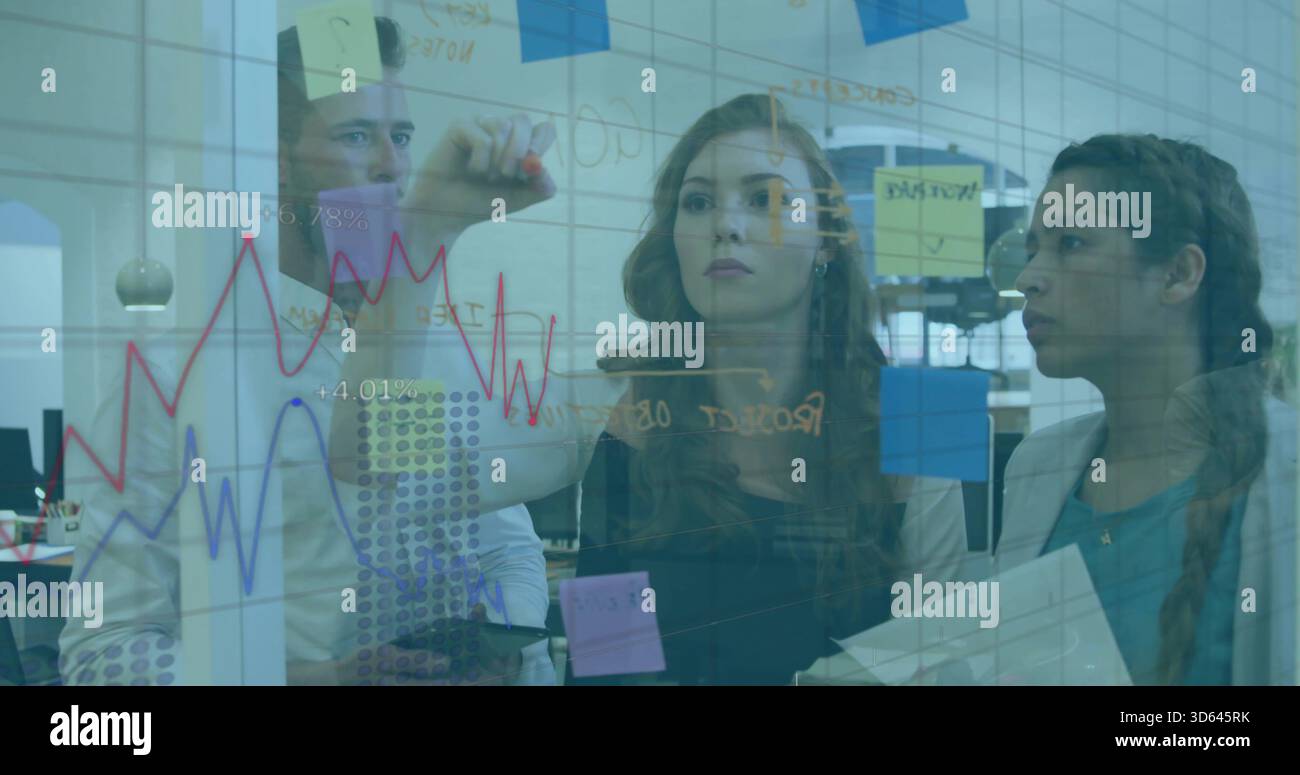 Writing woman in dark top drawing graphs on glass whiteboard at open office with sticky notes Stock Photo