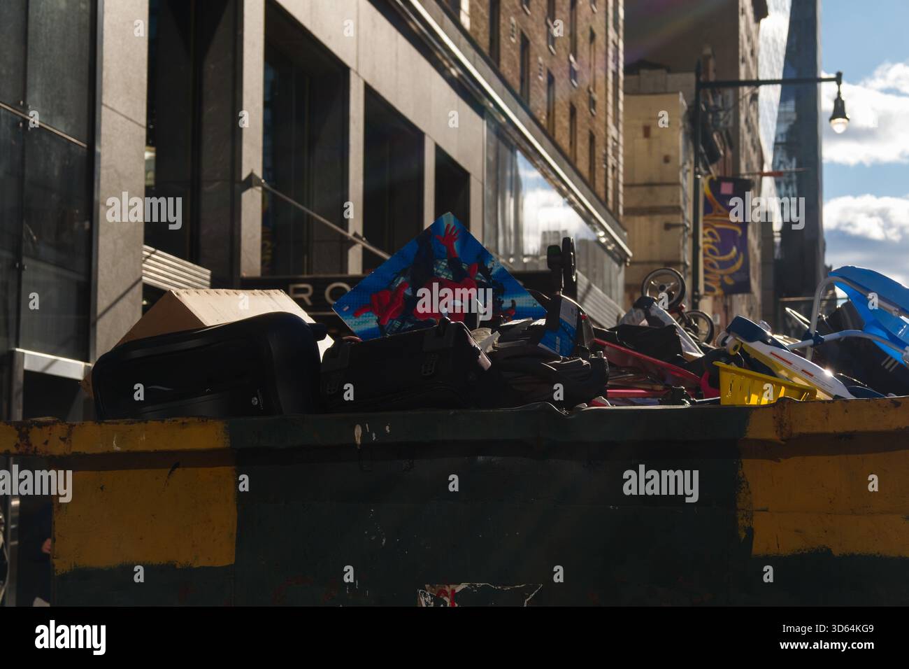 New York, New York, USA. 17th Nov, 2025. A heap of discarded personal  effects including luggage, infant car seats, disassembled playpens,  strollers, toys and articles of clothing fill a dumpster outside of