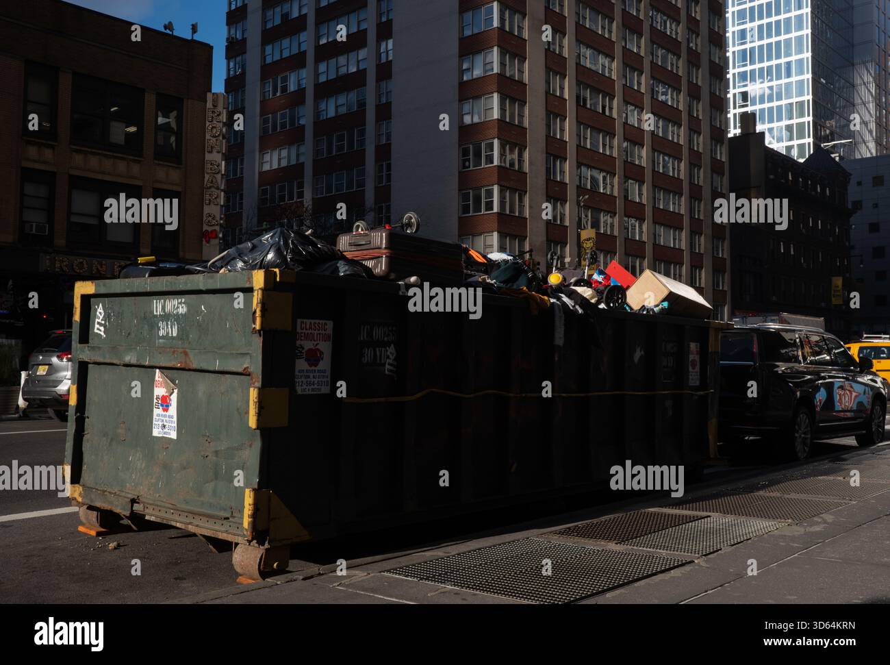 New York, New York, USA. 17th Nov, 2025. A heap of discarded personal  effects including luggage, infant car seats, disassembled playpens,  strollers, toys and articles of clothing fill a dumpster outside of