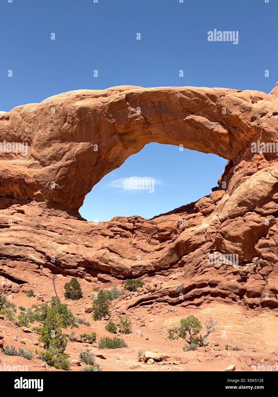 Window hole in a sandstone rock formation on the Windows Trail in the Arches National Park near Moab, Utah - Smartphone Captured Stock Image