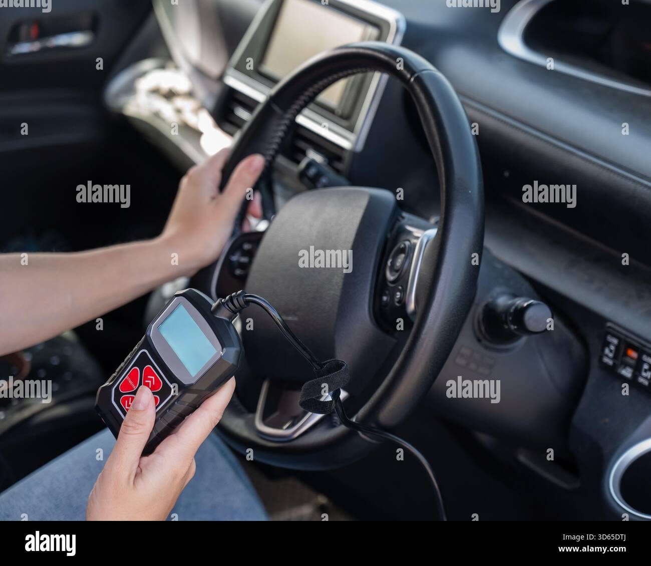 Woman using OBD2 diagnostic scanner.  Stock Photo