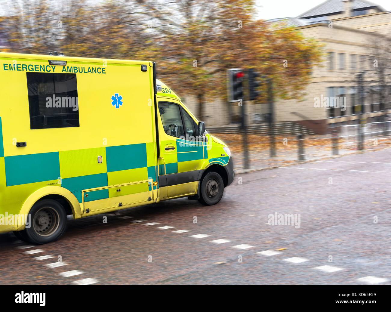UK Emergency ambulance in motion  in urban area of newcastle upon tyne with blurred trees and buildings in the background - Smartphone Captured Stock Image