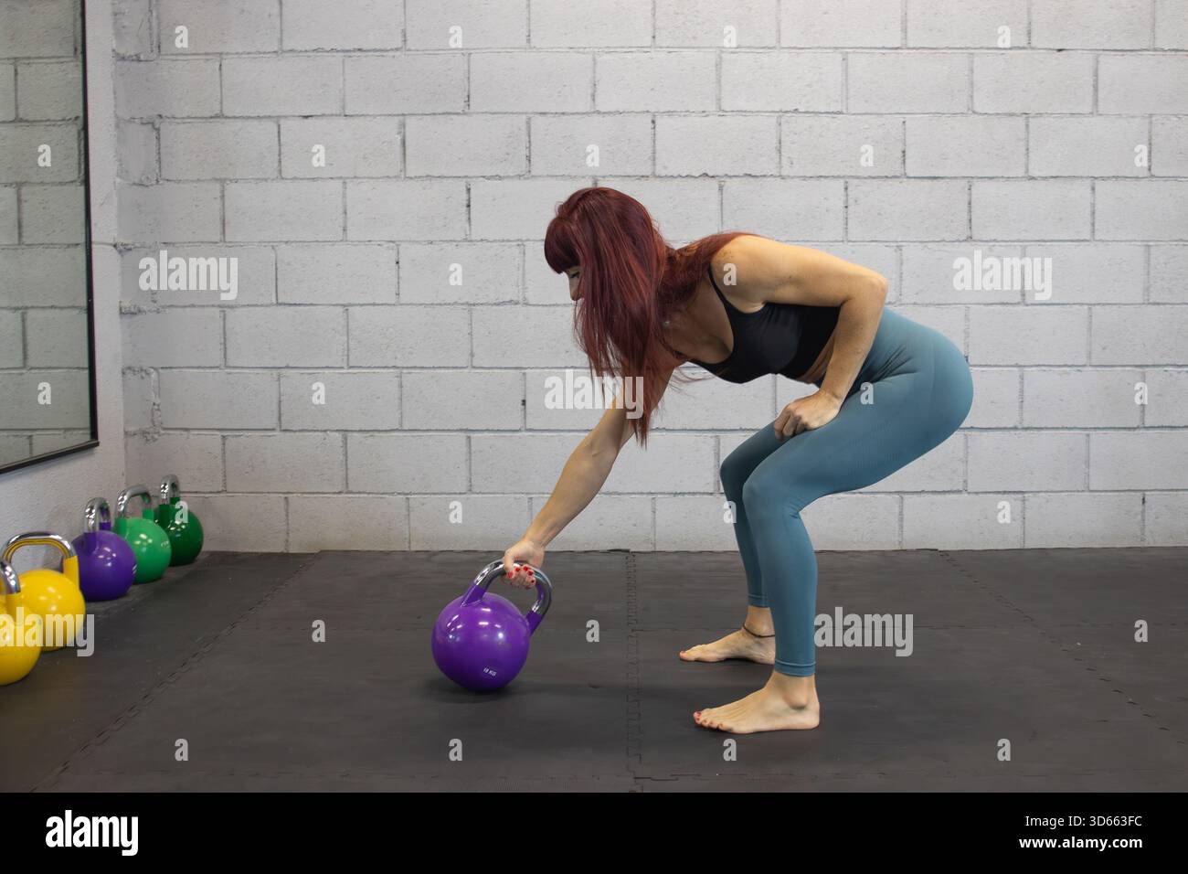 Preparing For A Controlled Kettlebell Deadlift With Proper Form Stock preparing-for-a-controlled-kettlebell-deadlift-with-proper-form-stock