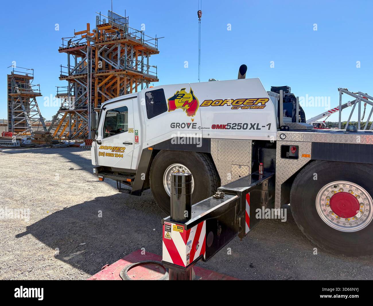Mobile wheeled construction crane with outriggers extended on a ...