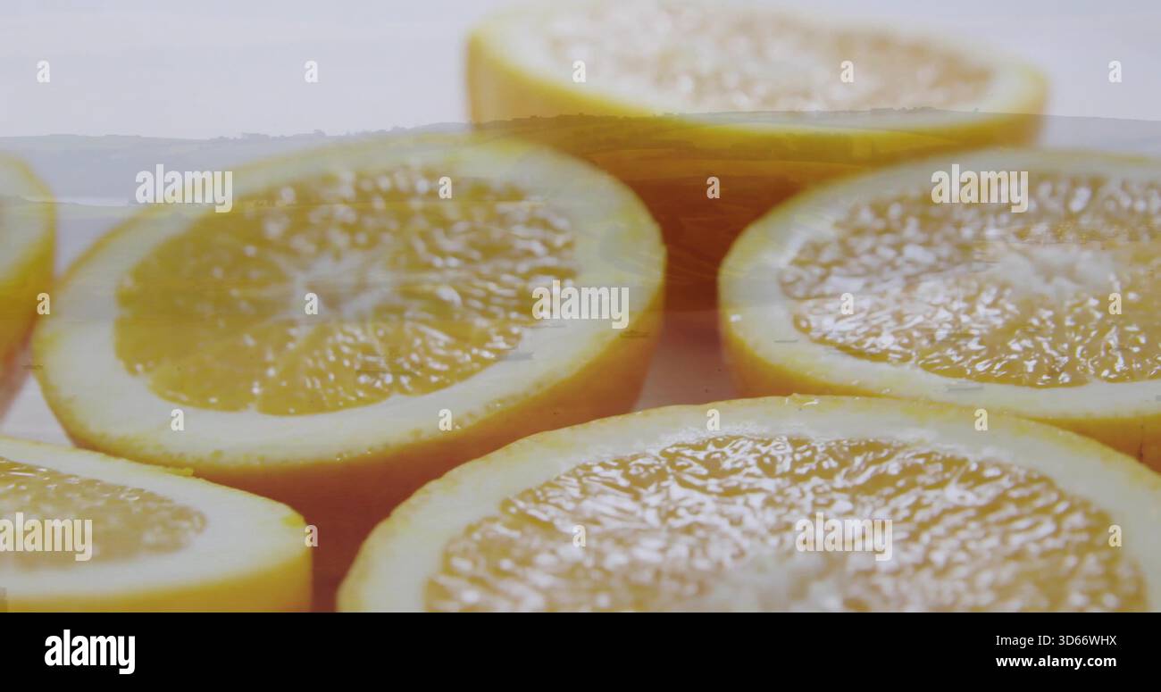 Displaying halved citrus cluster resting on pale tabletop, front-right half revealing juice Stock Photo