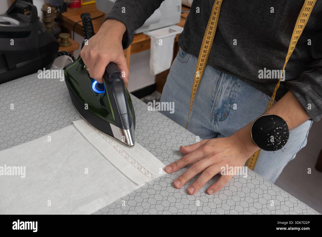 Seamstress concentrating while working on a sewing machine in her workshop Stock Photo