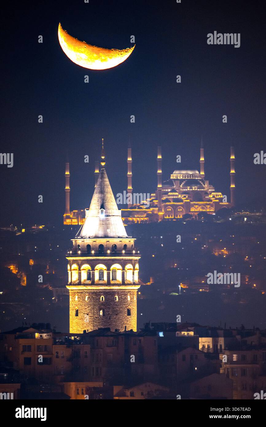FILE - The crescent moon rises behind the Camlica mosque and Galata ...