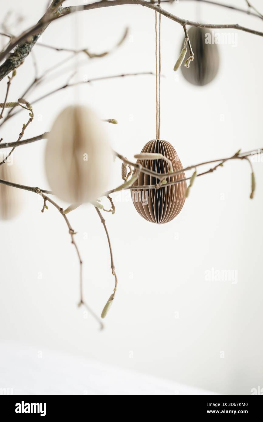 Easter paper eggs hanging on branches. Scandinavian-style Easter decorations. Stock Photo