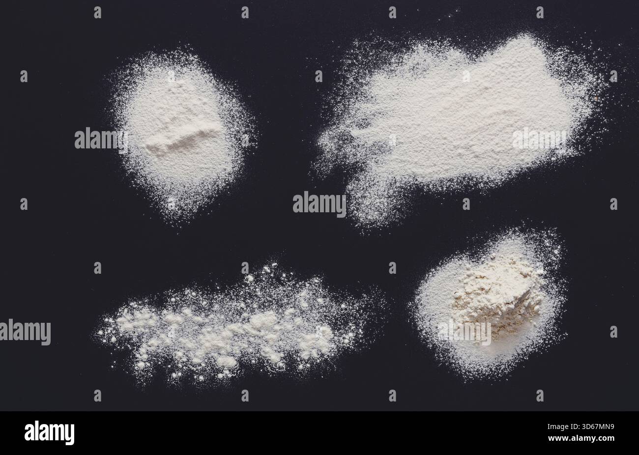 Sprinkled wheat flour splash spots on black background Stock Photo