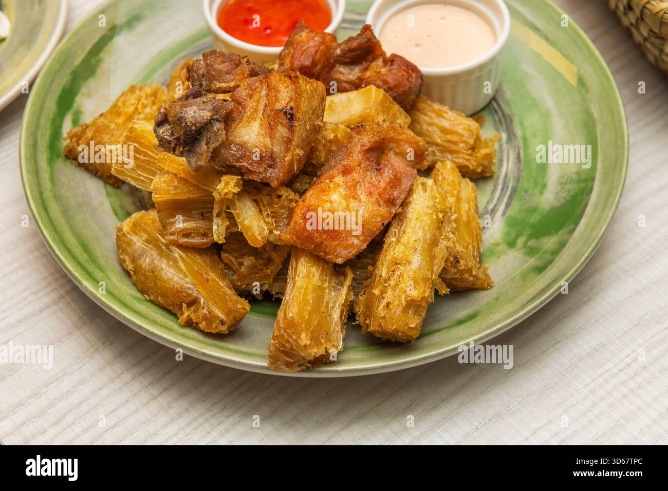 Delicious fried yuca in large wedges with smoky chipotle mayonnaise and lemon for dipping Stock Photo