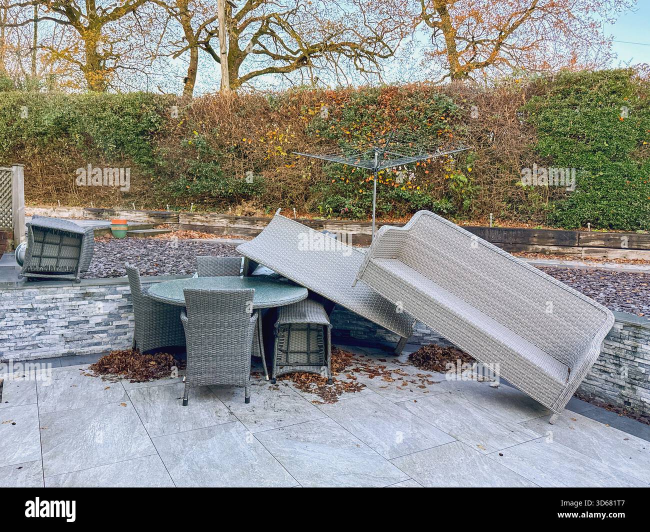 Rattan garden furniture piled up after the impact of very strong winds from a storm. No people. - Smartphone Captured Stock Image