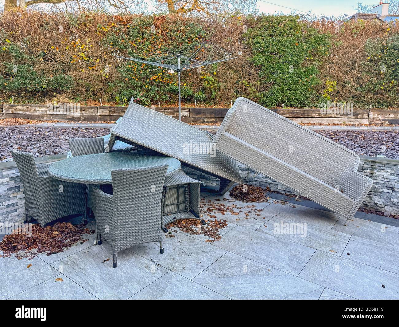 Rattan garden furniture piled up after the impact of very strong winds from a storm. No people. - Smartphone Captured Stock Image